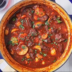 a pot filled with stew and vegetables on top of a table