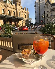 a glass of wine sitting on top of a table next to a bowl of food