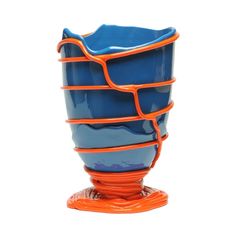 a blue and orange vase sitting on top of a table