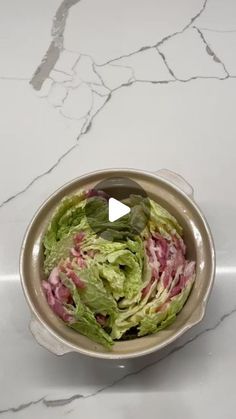 a bowl filled with lettuce sitting on top of a counter