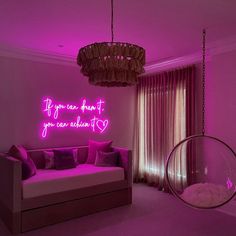 a living room filled with furniture and pink lighting