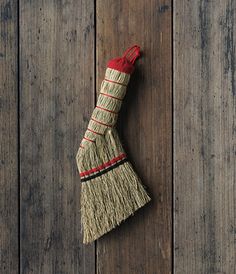 a small broom on a wooden surface