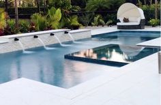 an outdoor swimming pool surrounded by trees and plants