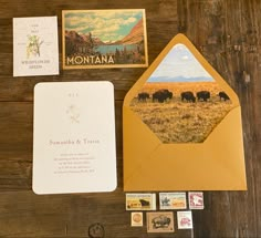 an envelope and some postcards on a wooden table with other items to make it look like they are in the wild