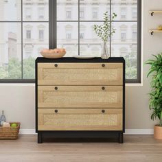 an empty room with a dresser and potted plant