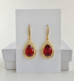 Luxury red ruby cubic zirconia bridal tear drop dangle earrings in gold plated brass setting. Earrings feature a large teardrop with pear cut red ruby cubic zirconia center surrounded by tiny round zirconia crystals. Teardrop dangles from a ear wire detailed with tiny zirconia crystals. Total length of the earrings is 3.8 cms. For matching necklace click: For earrings/necklace set click: For matching bracelet click: To browse my collection click : https://www.etsy.com/shops/fantasycrystals Bridal Gold Earrings, Red Gold Wedding, Gold Bridesmaid Jewelry, Rose Gold Earrings Wedding, Rose Gold Bridal Jewelry, Purple Drop Earrings, Black Crystal Earrings, Rose Gold Bridal Earrings, Red Bridesmaid