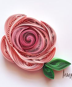 an origami rose with two green leaves on the top and one pink flower in the middle