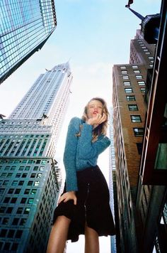 a woman standing in the middle of tall buildings