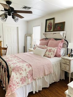 a bed sitting in a bedroom next to a window with a fan on top of it