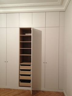 an empty closet with white cabinets and drawers