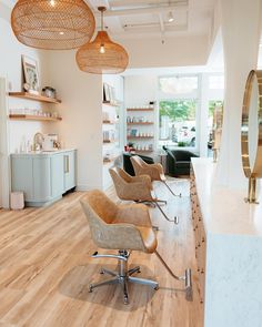 the interior of a hair salon with chairs and shelves