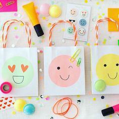 three bags with different designs on them sitting next to some confetti and candy