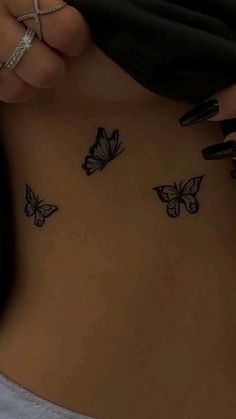 a woman with butterfly tattoos on her stomach