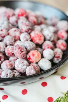 a bowl filled with powdered cranberries on top of a polka dot table cloth