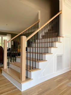 a wooden stair case next to a hard wood floor