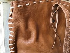 a brown leather purse with white stitching on it