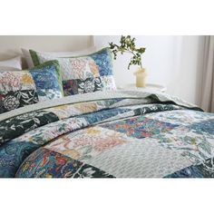 an image of a bed with colorful quilts on it