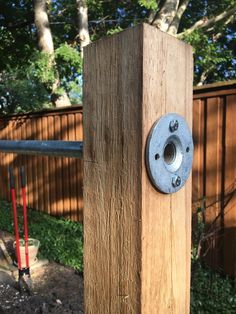 a wooden post with a metal button on it