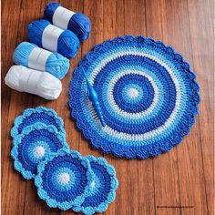 blue crocheted placemats and yarn on wooden floor with ball of thread