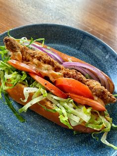 a sandwich with meat and vegetables on a blue plate