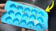 an egg tray filled with blue eggs being held by someone's hand