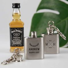 two personalized flasks and keychains are sitting next to each other