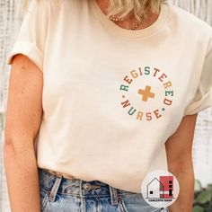 a woman with blonde hair wearing a white t - shirt that says register nurse on it