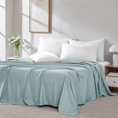 a bed with white pillows and blue sheets