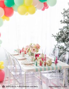 a table set for a party with balloons in the background