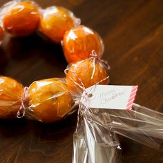 some oranges wrapped in plastic and sitting on a table with a happy birthday tag