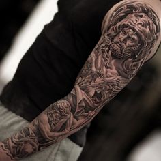 a man's arm with tattoos on it and an angel in the middle of his arm