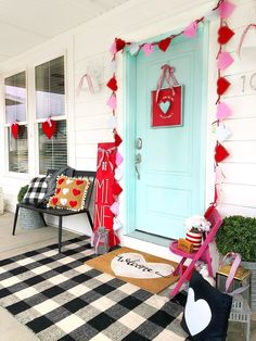 a front porch decorated for valentine's day with heart decorations and paper garlands