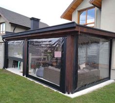 a house with a covered patio in front of it's windows and grass area