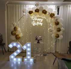 a birthday party with balloons, lights and a cake in the shape of number twenty