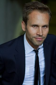 a man in a suit and tie looking at the camera