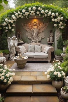 an outdoor living room with white roses and angel statues