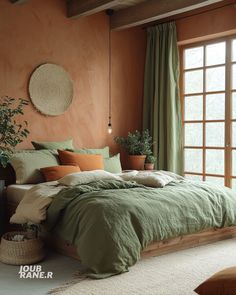 a bedroom with an orange wall and green bedding in front of a large window