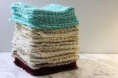 a stack of crocheted dishcloths sitting on top of a marble counter