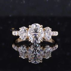 three stone diamond ring with reflection on black surface