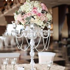 a candelabra filled with flowers and candles on top of a white table