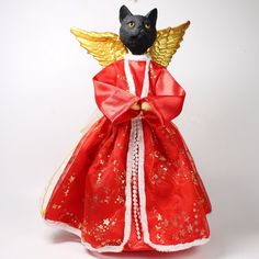 a siamese cat dressed in red and gold with wings on it's back