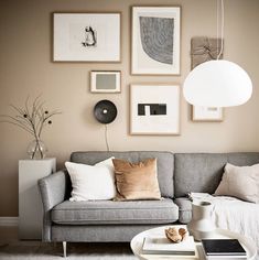 a living room filled with furniture and framed pictures on the wall above it's coffee table