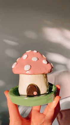 a hand holding a small mushroom shaped cake