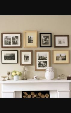 there are many framed pictures on the wall with vases and candles in front of them