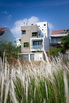 an apartment building is surrounded by tall grass