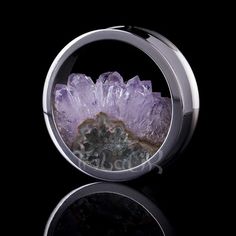 an amethorate ring with purple crystals in the center on a black background