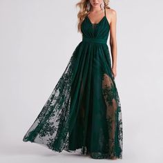 a woman in a long green dress with sheer lace on the bottom and an open back