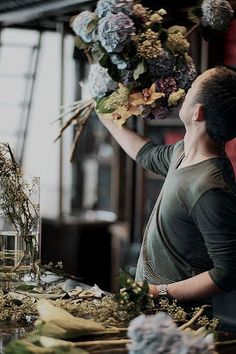 a man is arranging flowers on a table