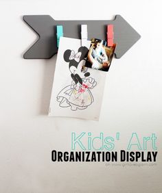 an arrow with pictures hanging on it and the words kids'art organization display