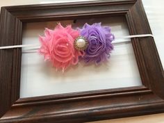 two flower hair clips are in a frame